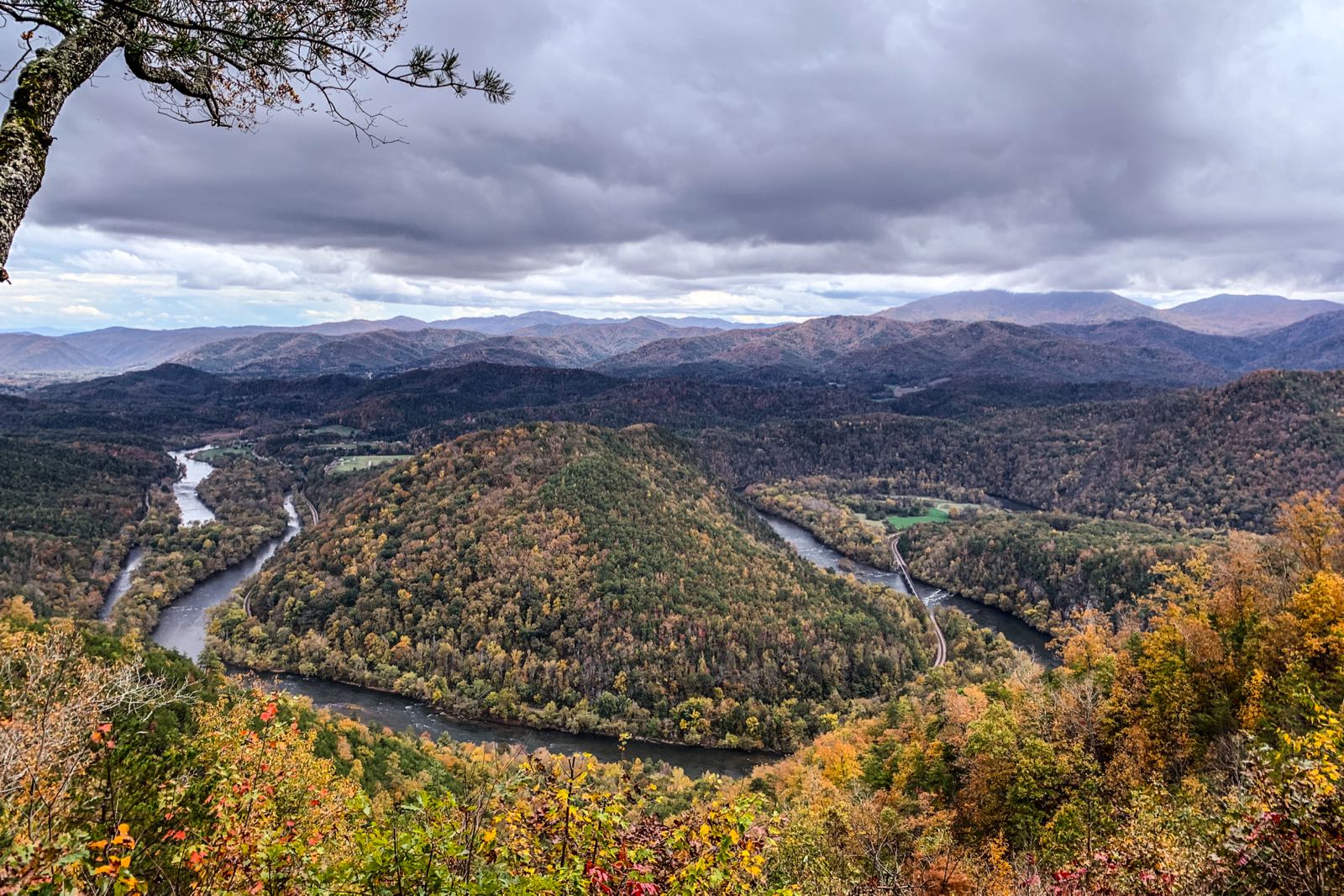 The French Broad River curves below autumn-colored ridges seen from Chimney Rocks in Cherokee National Forest